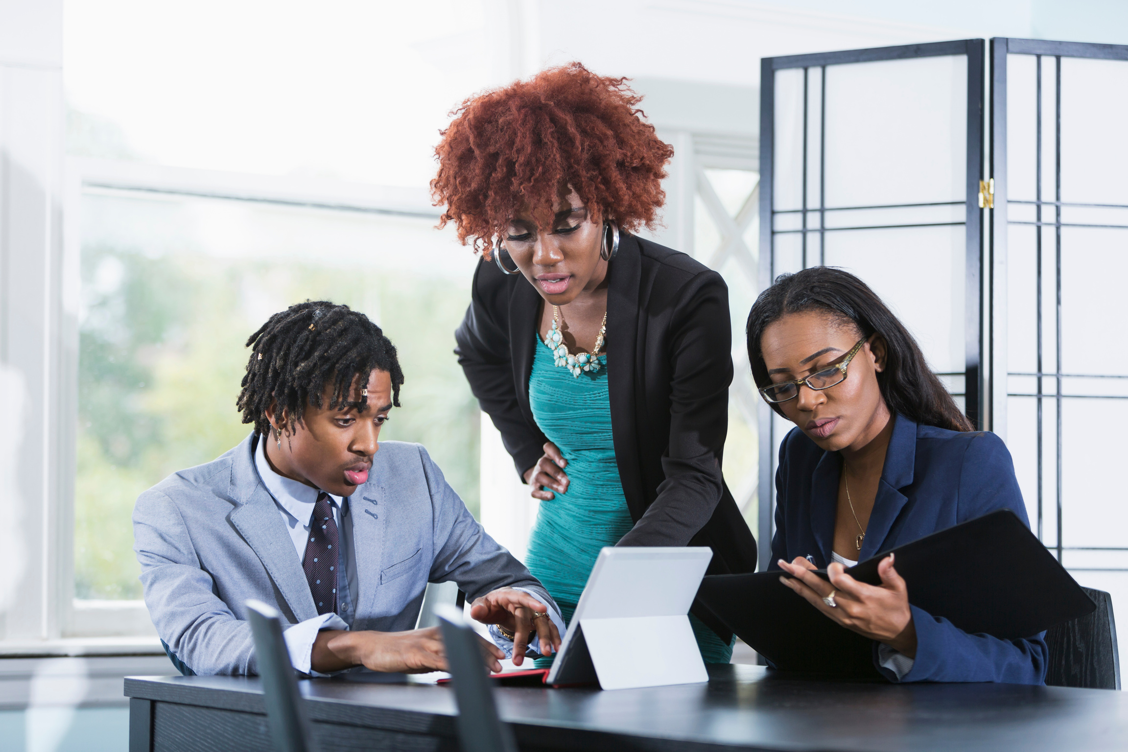 Team of Three Young Businesspeople Working Together